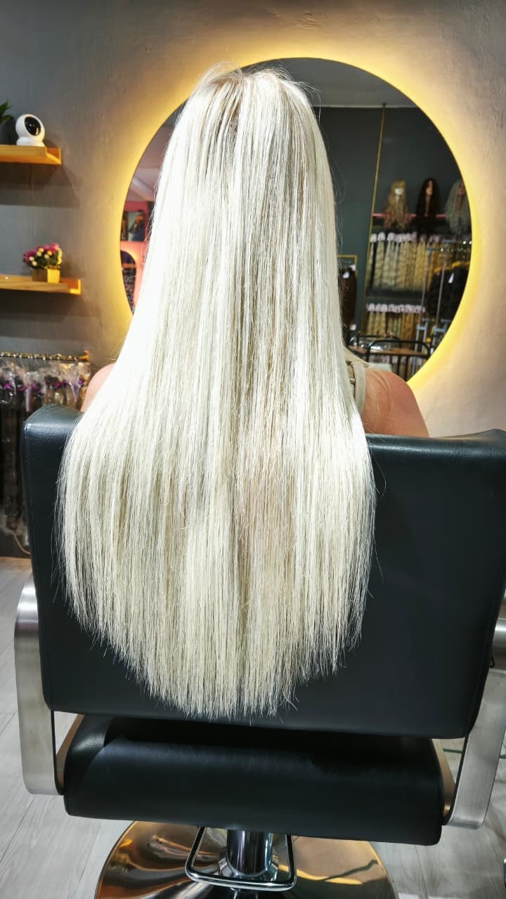 Long blonde extensions — finished result, salon chair