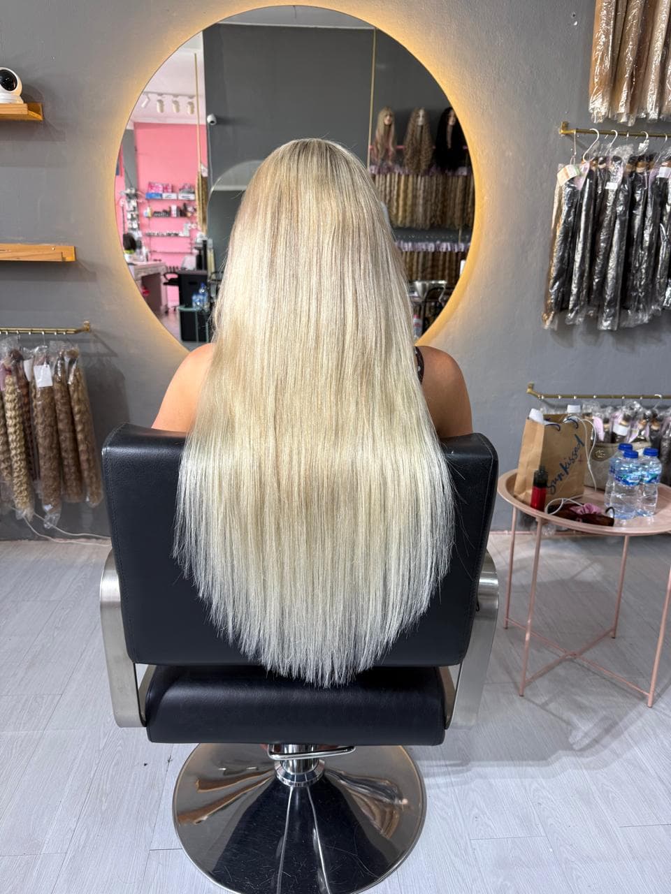 Same client after — blonde length past the waist, thick to the ends