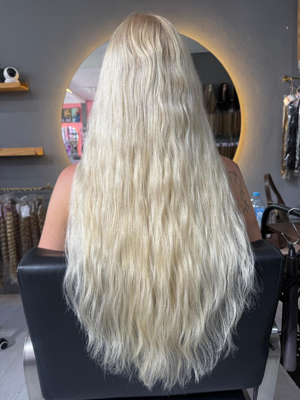 Same client after — fuller blonde waves past the waist