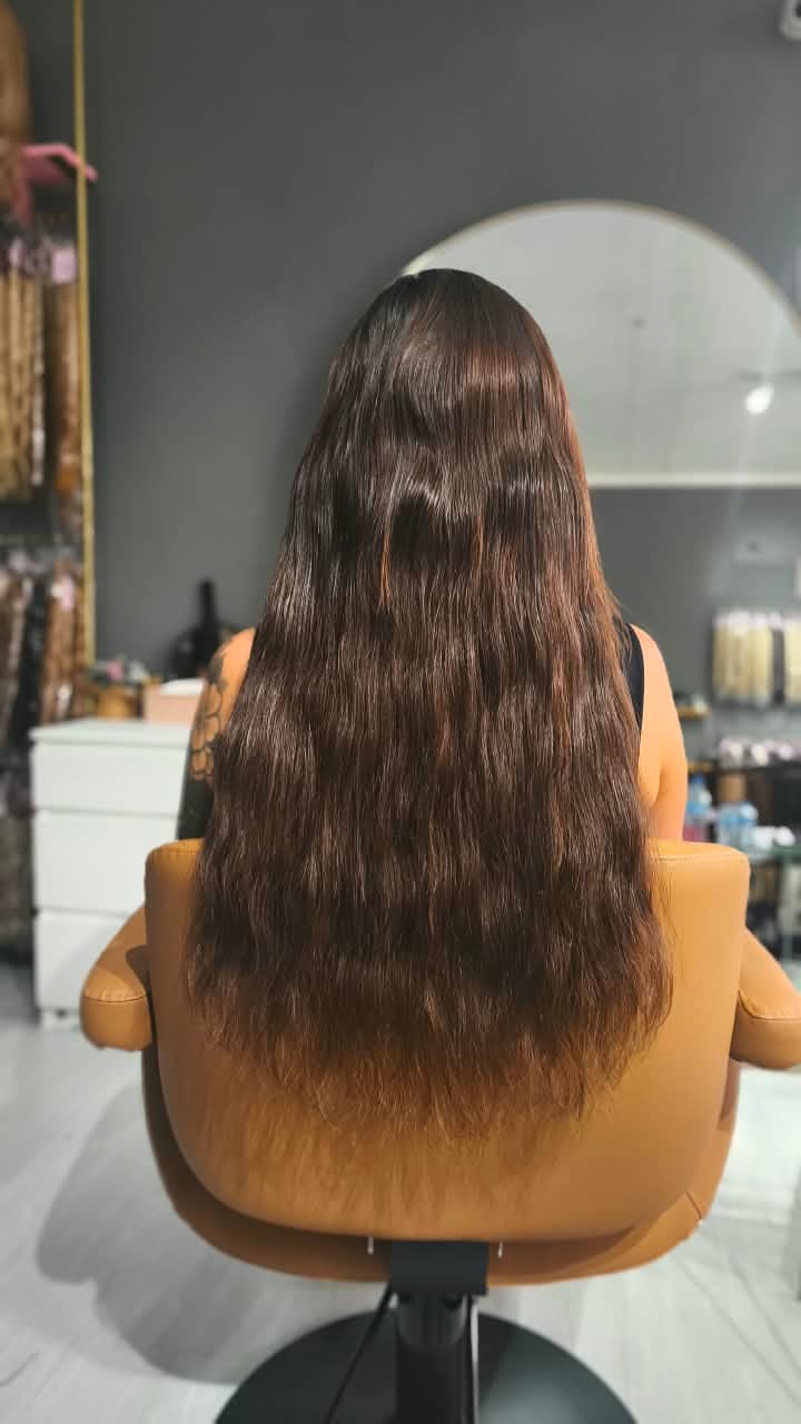 Same client after — long brown waves past the waist, Weft double 150 g