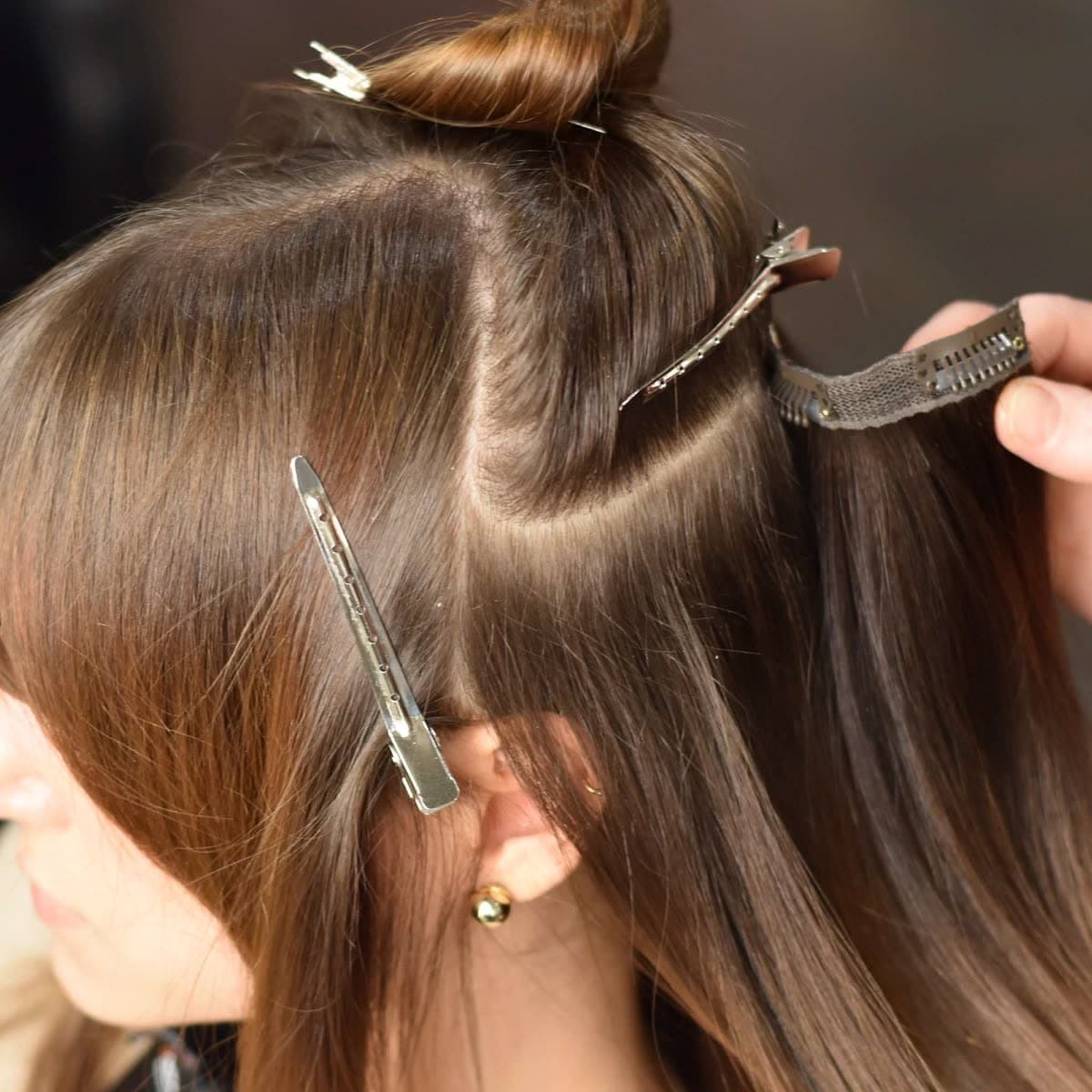 A Clip-In weft being clipped into a sectioned parting