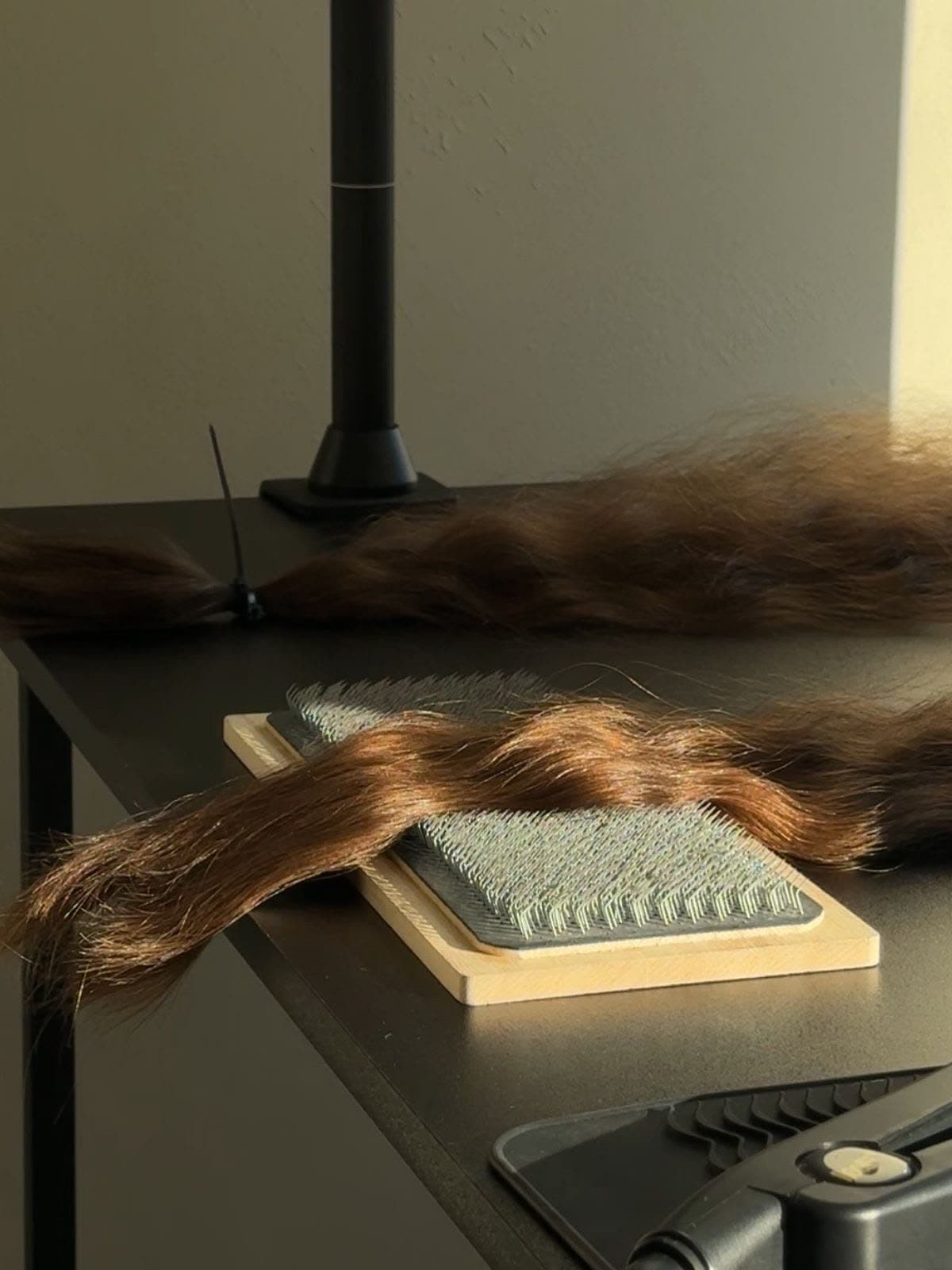 Studio bench — hair drawn across a hackle board during preparation