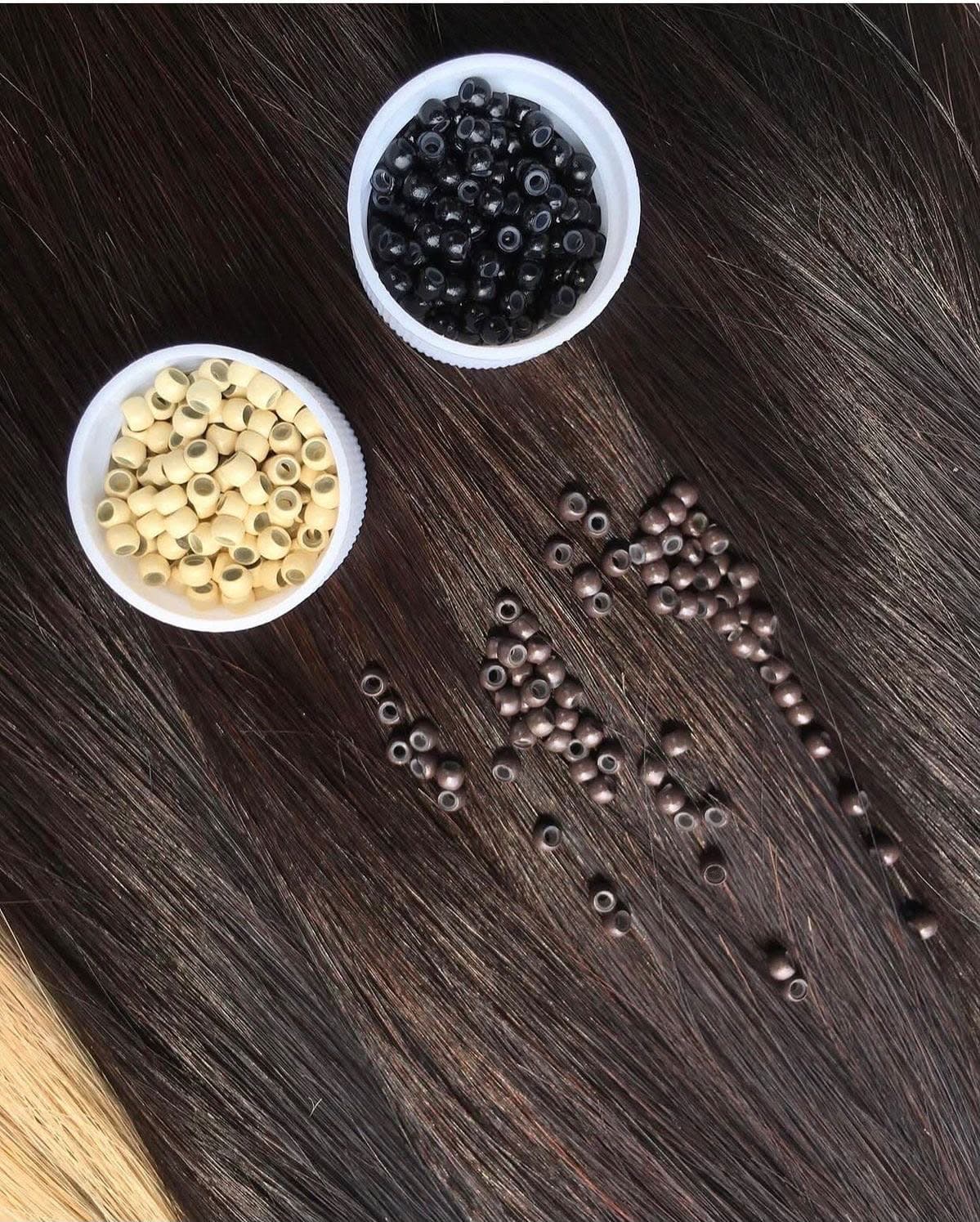 Micro beads in black and blonde, laid out on straight dark hair