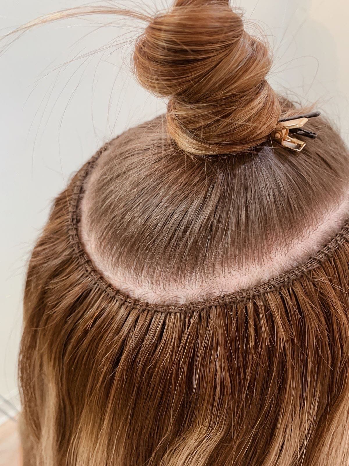 Weft sewn into a curved track around the crown