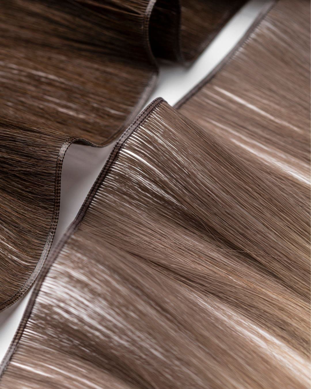 Hand-tied weft close-up — fine seam running along the top edge